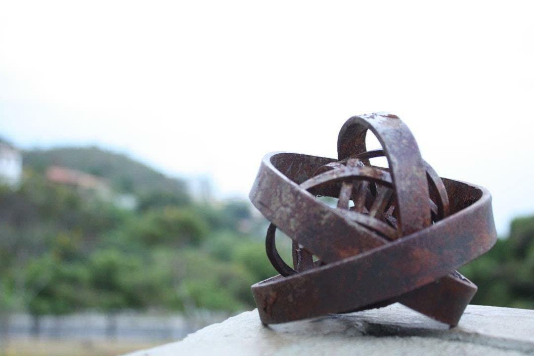 Peças Autorais 5 Escultura esférica de anéis entrelaçados em aço corten, ao ar livre