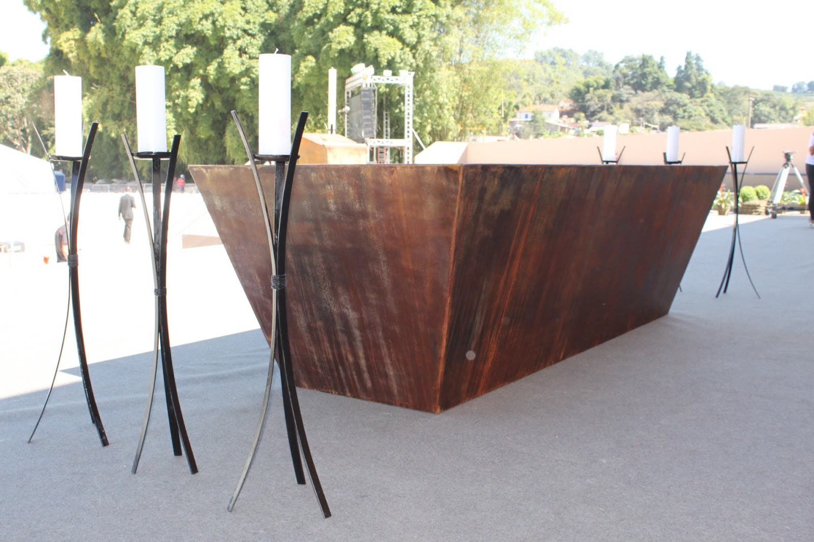 Peças Autorais 7 Mesa de recepção em aço corten ao ar livre, ladeada por candelabros de ferro forjado
