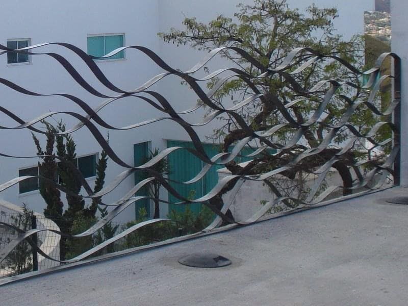 Guarda-corpo metálico com desenho ondulado em área externa