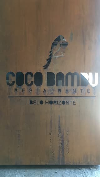 Painel em aço corten com a logomarca vazada no metal, em detalhe
